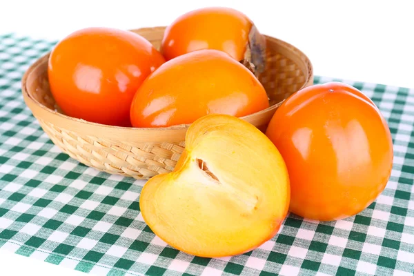 Ripe persimmons in wicker basket on table on white background — Stock Photo, Image