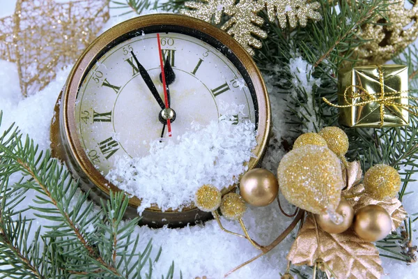 Clock with fir branches and Christmas decorations under snow close up — Stock Photo, Image