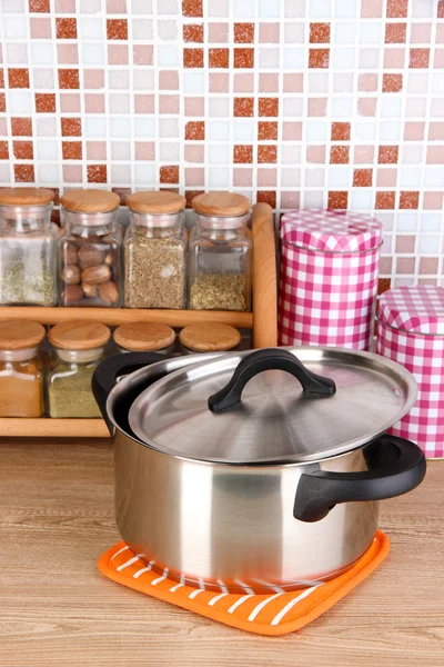 Pot en specerijen in keuken op tafel op mozaïek tegels achtergrond — Stockfoto