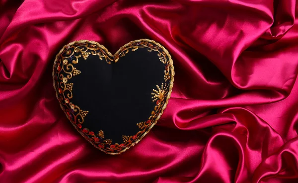 Decorative black heart, on color fabric — Stock Photo, Image