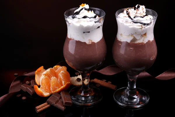 Sabroso postre con chocolate, crema y salsa de naranja, sobre fondo de color oscuro —  Fotos de Stock
