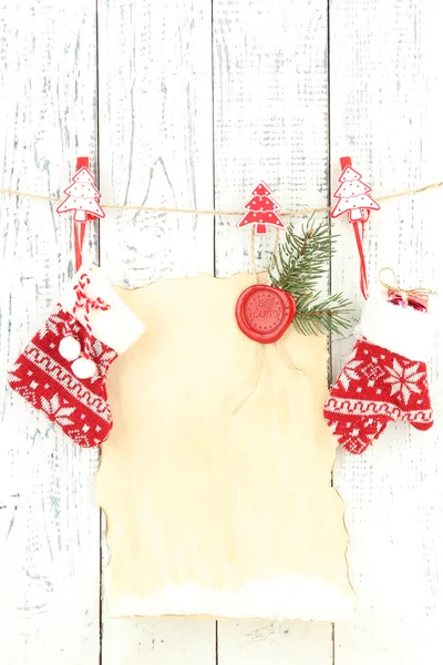 Чистый лист с рождественским декором висит на белой деревянной стене — стоковое фото