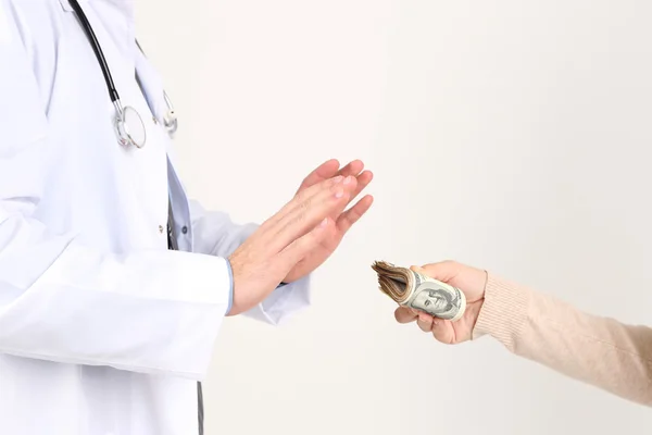 Mannelijke arts ontvangen van geld uit patiënt, geïsoleerd op wit — Stockfoto