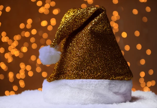 Santa klobouk na sněhu na pozadí světla — Stock fotografie