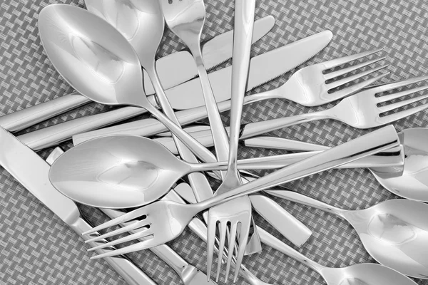 Forks, knifes and spoons on grey mat close-up — Stock Photo, Image