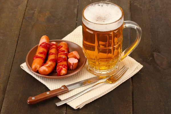Beer and grilled sausages on wooden background — Stock Photo, Image