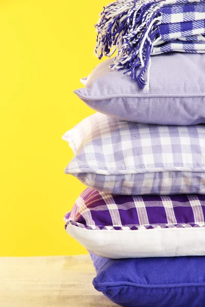 Wzgórze kolorowe poduszki i kratki na żółtym tle — Zdjęcie stockowe
