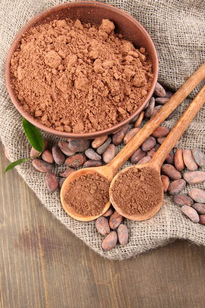 Какао-порошок і какао-боби на дерев'яному фоні — стокове фото