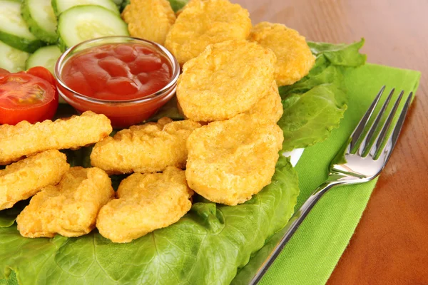 Fried chicken nuggets with vegetables and sauce on table — Stock Photo, Image