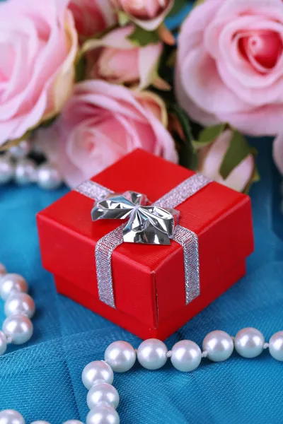 Rosa e confezione regalo su stoffa blu — Foto Stock