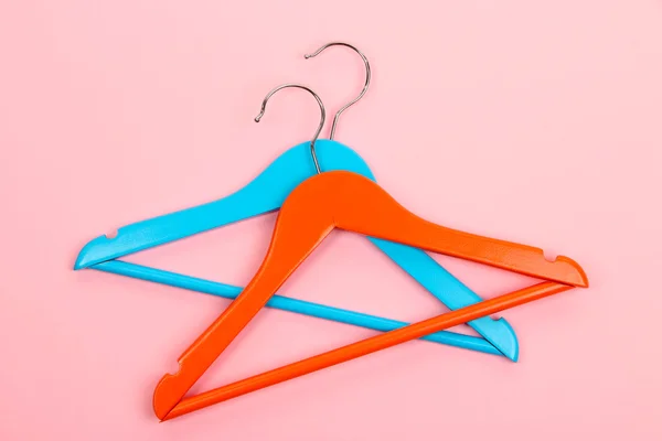 Colorful clothes hangers on pink background — Stock Photo, Image