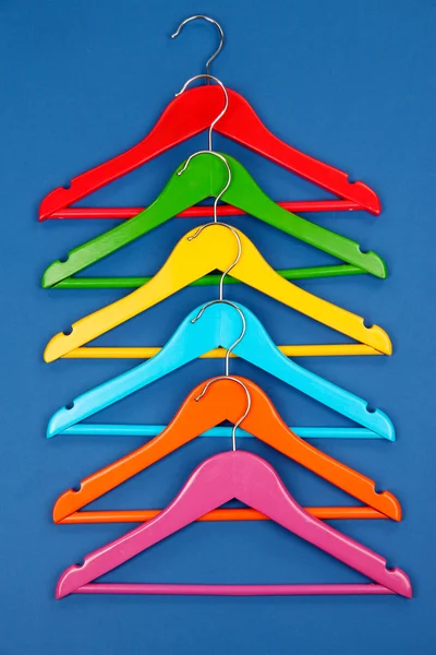 Cintres de vêtements colorés sur fond bleu — Photo
