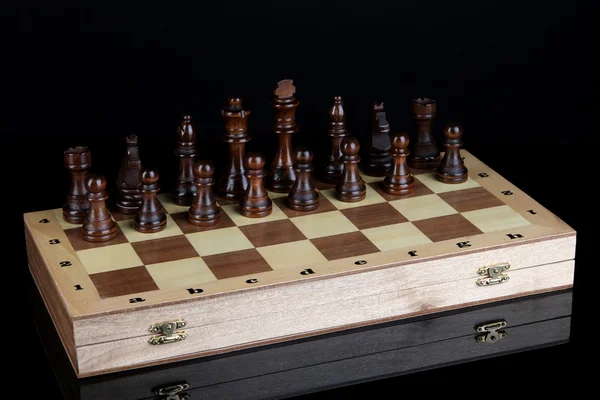 Échiquier avec pièces d'échecs isolées sur noir — Photo