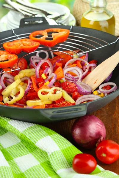 Vegetables in wok on wooden table on natural background — Stock Photo, Image