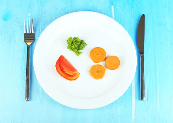 Small portion of food on big plate on wooden table close-up — Stock Photo, Image