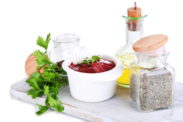 Raw liver in bowl with spices and condiments isolated on white — Stock Photo, Image