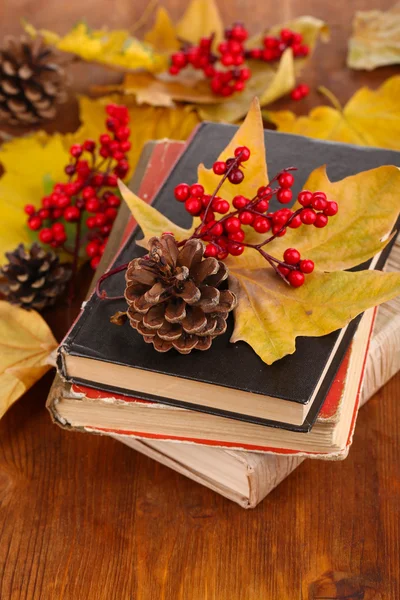Books and autumn leaves on wooden table close-up — Stock Photo, Image