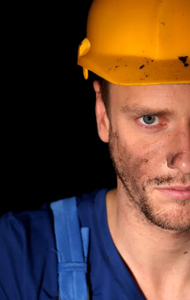 Porträt eines jungen Arbeiters auf dunklem Hintergrund — Stockfoto