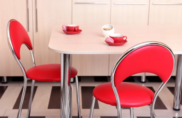 Σύγχρονες κόκκινες καρέκλες κοντά τραπέζι στην κουζίνα — Φωτογραφία Αρχείου