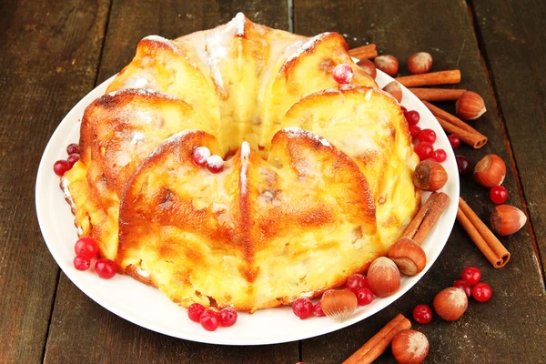 Schmackhafter hausgemachter Kuchen mit Beeren, Nüssen und Gewürzen, auf Holztisch — Stockfoto