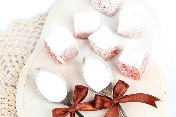 Smakelijke oosterse snoepjes (Turks fruit) met poedersuiker, op houten bureau — Stockfoto