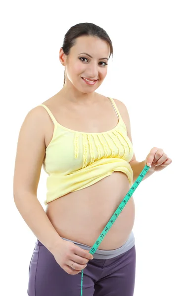 Young pregnant woman measuring her belly isolated on white — Stock Photo, Image