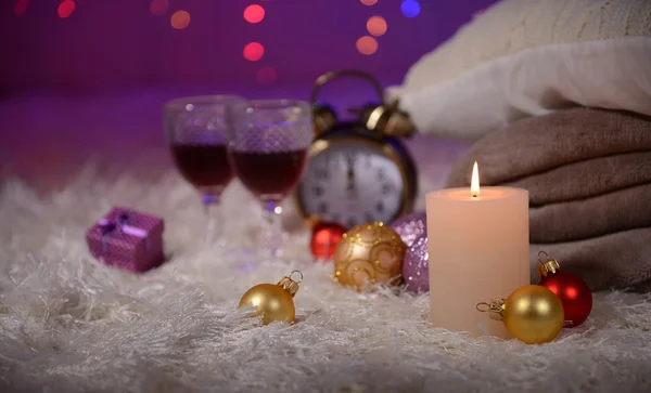 Composition avec plaids, bougies et décorations de Noël, sur tapis blanc sur fond lumineux — Photo