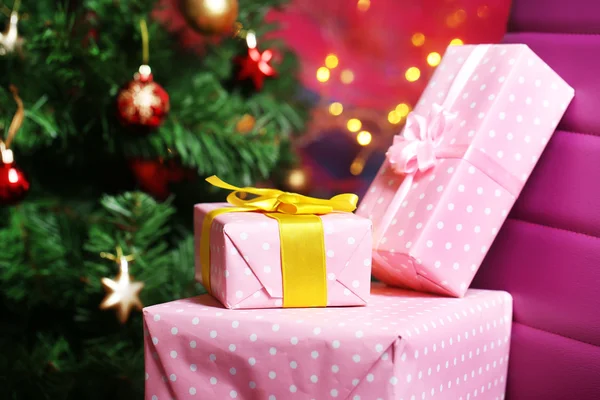 Christmas gift boxes on Christmas tree background — Stock Photo, Image