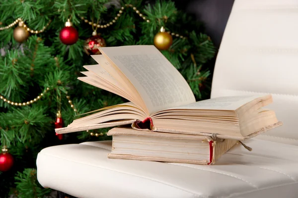 Composição com livros em cadeira no fundo da árvore de Natal — Fotografia de Stock