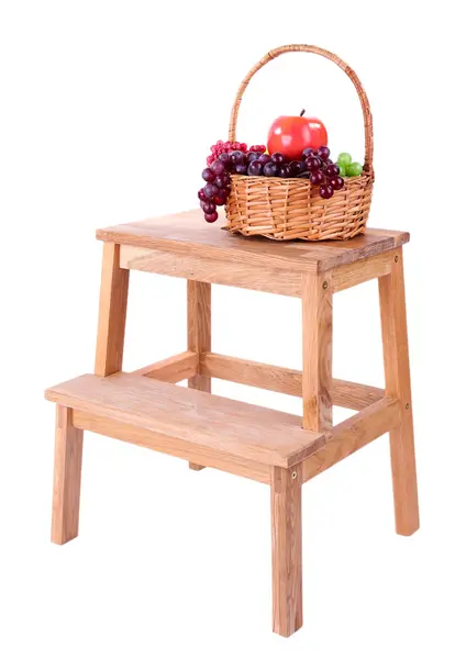 Wicker basket with fruits, on small wooden ladder, isolated on white — Stock Photo, Image