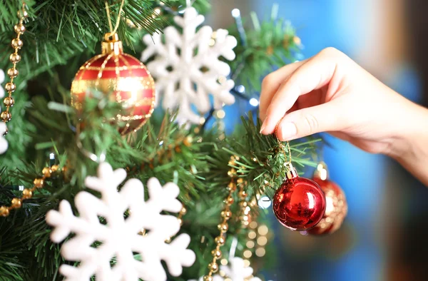 Decorating Christmas tree on bright background — Stock Photo, Image