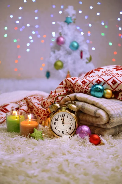 Composition avec plaids, bougies et décorations de Noël, sur tapis blanc sur fond lumineux — Photo