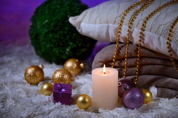 Composition with plaids, candles and Christmas decorations, on white carpet on bright background — Stock Photo, Image