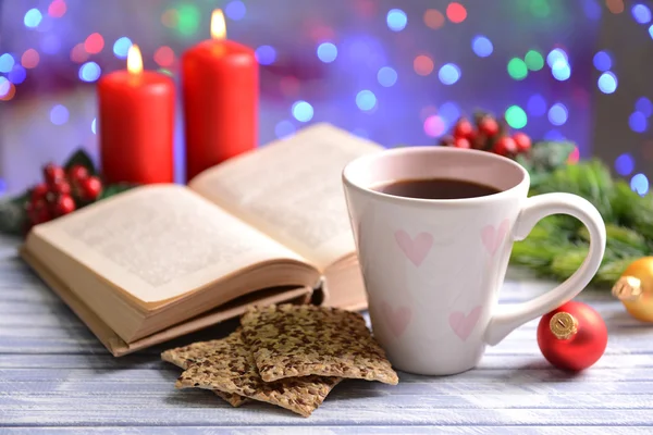 本书带杯咖啡和圣诞装饰品上明亮的背景表格的组成 — 图库照片