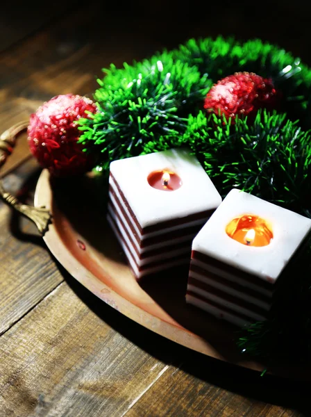 Velas ardientes con decoraciones navideñas sobre fondo de madera — Foto de Stock