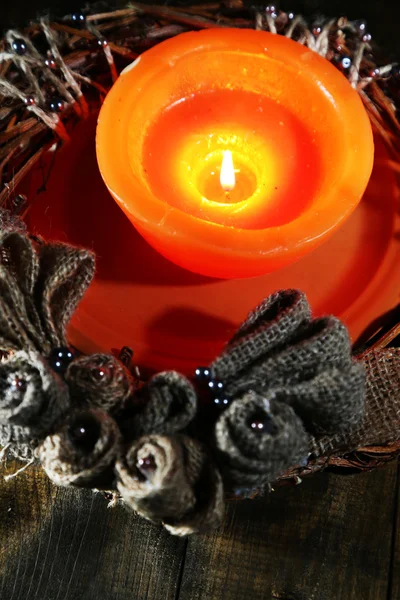 Burning candle with Christmas wreath on wooden background — Stock Photo, Image