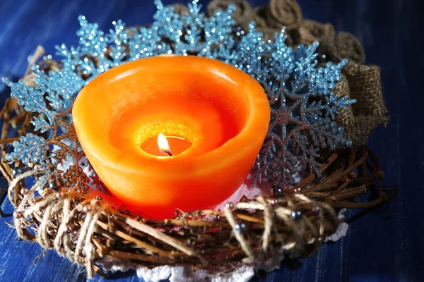 Burning candle with Christmas decorations on color wooden background — Stock Photo, Image