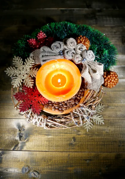 रंग लकड़ी की पृष्ठभूमि पर क्रिसमस सजावट के साथ जलती हुई मोमबत्ती — स्टॉक फ़ोटो, इमेज