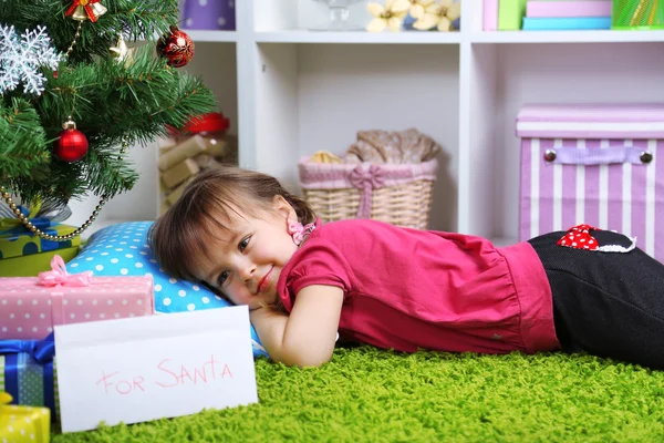 어린 소녀 방에 크리스마스 트리 근처 거짓말 — 스톡 사진