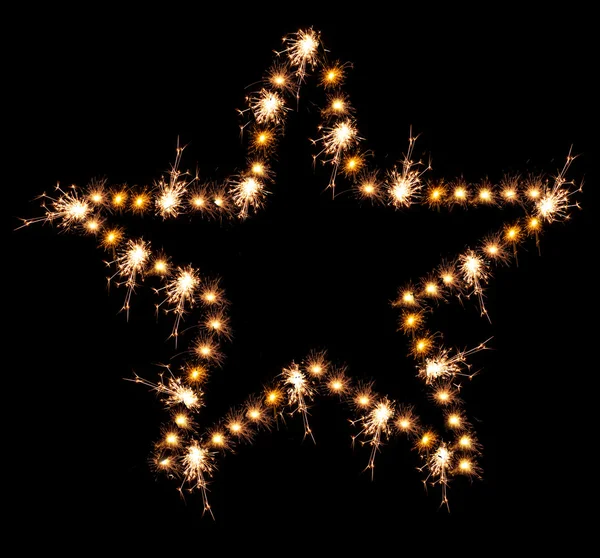 Christmas sparklers in shape of star on black background — Stock Photo, Image