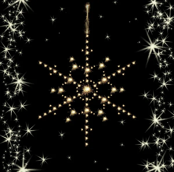 Christmas sparklers in shape of snowflake on black background — Stock Photo, Image