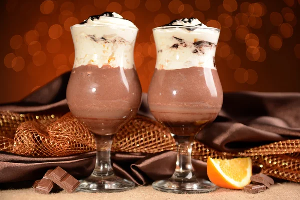 Lekker dessert met oranje, chocolade en crème saus, op tafel, op lichten achtergrond — Stockfoto