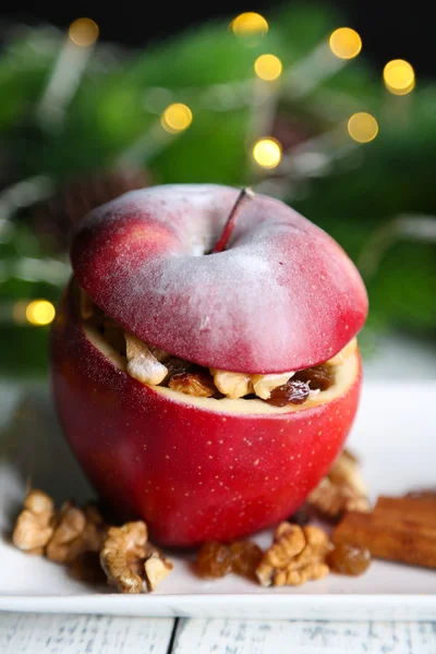 Фаршированное рождественское яблоко с орехами и изюмом на столе — стоковое фото
