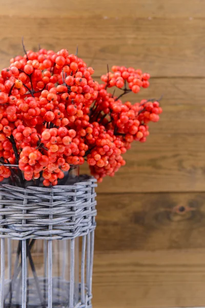 枝編み細工品花瓶、木製の背景上に人工の果実 — ストック写真