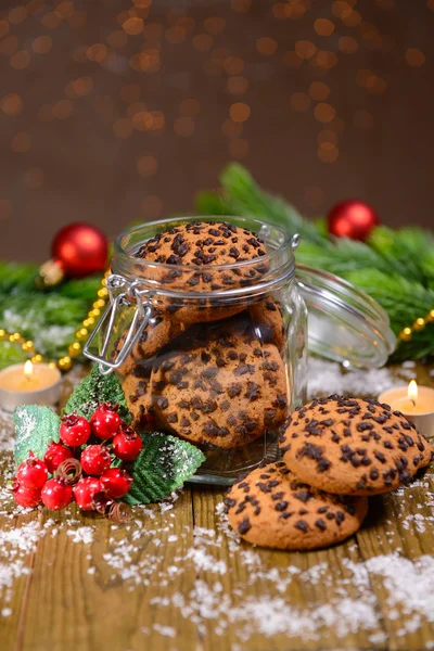 Heerlijke kerstkoekjes in pot op tafel op bruine achtergrond — Stockfoto