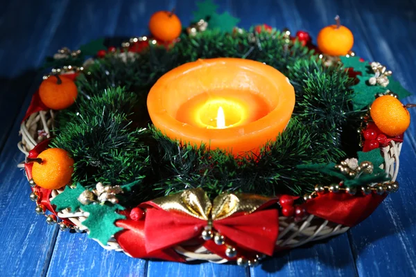 Égő gyertya, karácsonyi díszek, színes fából készült háttér — Stock Fotó
