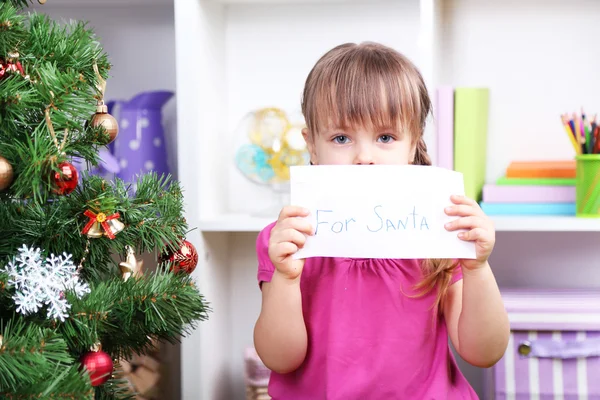 Bambina con lettera per Babbo Natale vicino all'albero di Natale in camera — Foto Stock