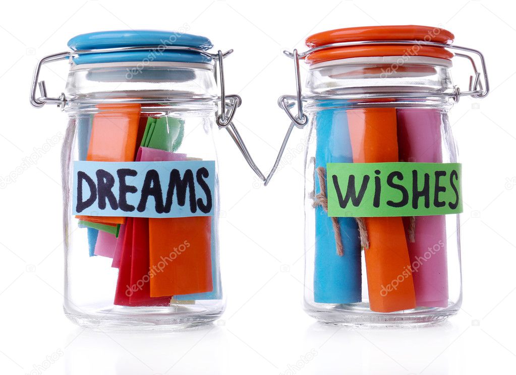 Dreams written on color rolled paper in glass jar, isolated on white