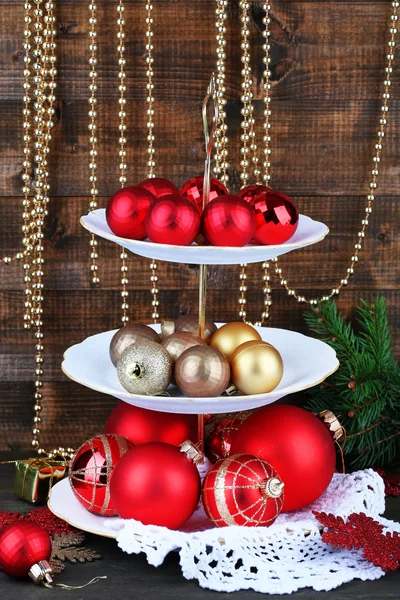 Christmas decorations on dessert stand, on wooden background — Stock Photo, Image