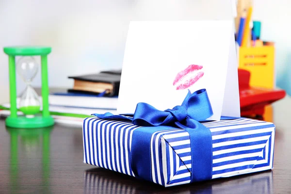 Gift with card for loved one on desktop on room background — Stock Photo, Image